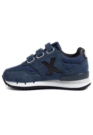 Zapatillas de deporte de ante azul con parte superior de tejido texturizado, tres tiras de Velcro, acento negro y mediopié blanco con una suela exterior de goma resistente.