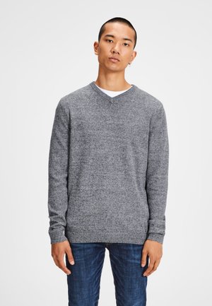 Grijze v-hals trui van gestructureerde gebreide stof, met lange mouwen en een aansluitende zoom, gecombineerd met donkerblauwe jeans.
