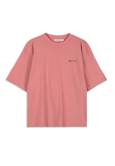 Ružový bavlnený tričko s voľným strihom, okrúhlym výstrihom a krátkymi rukávmi. Na prednej strane sa nachádza malé čierne vyšívané písmo.