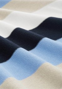 Stickad tyg med horisontella ränder i ljusblått, mörkblått, beige och vitt. Strukturerad yta med en mjuk finish.