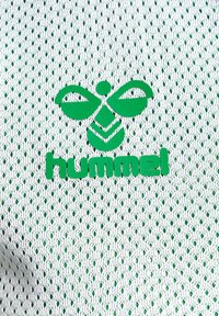 Groen logo met een bijontwerp en het woord "hummel" op wit gaasstof met een netachtige textuur en gelijkmatig verdeelde perforaties.
