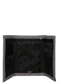 Billetera de tela gris con bolsillos de malla negra, múltiples compartimentos para tarjetas y cierre a presión. Presenta una textura suave y un diseño compacto.