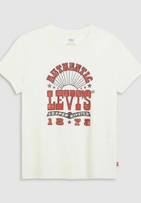 Camiseta blanca de manga corta con un diseño gráfico rojo que presenta "AUTHENTIC LEVI'S" y "COPPER RIVETED 1873", estrellas y un patrón de estallido solar.