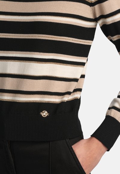 Svītrains džemperis melnā, bēšā un baltā krāsā ar zelta akcentiem, ar ribotu apakšmalu un logotipa detaļu pie jostasvietas.