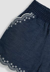 Donkerblauwe shorts met een smockband in de taille, voorzien van witte geborduurde bloempatronen langs de zoom en de randen van de zakken. Zachte denimstructuur.