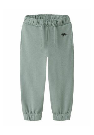 Pantalon de jogging vert clair pour tout-petit avec taille et poignets élastiques, cordons, et petit logo dinosaure noir sur la hanche gauche.