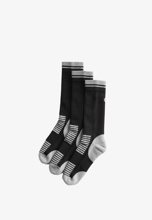 Drie zwarte sneakersokken met grijze hielen, tenen en gestreepte details, opgestapeld tegen een witte achtergrond.