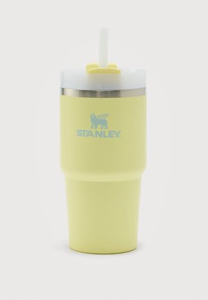 Gelber Stanley isolierter Becher mit transparentem Deckel und weißem Strohhalm, Edelstahlrand und Flügel-Löwen-Logo auf der Vorderseite.