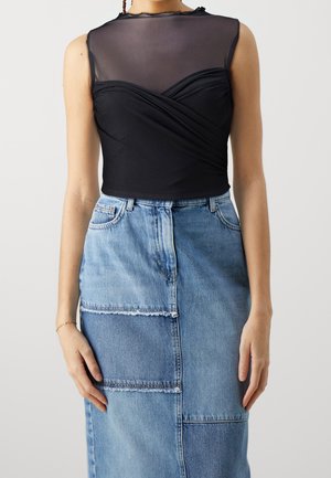 Musta, istuva yläosa, jossa verkkokangasyläosa ja kääritty muotoilu. Yhdistetty farkkuhameeseen, jossa on vaihtelevat sävyt ja tilkkutöityyli.