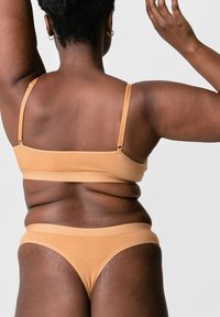 Nude bruine naadloze beha en ondergoedset met verstelbare bandjes, gladde stof en minimalistisch ontwerp, die een eenvoudige, moderne uitstraling laat zien.