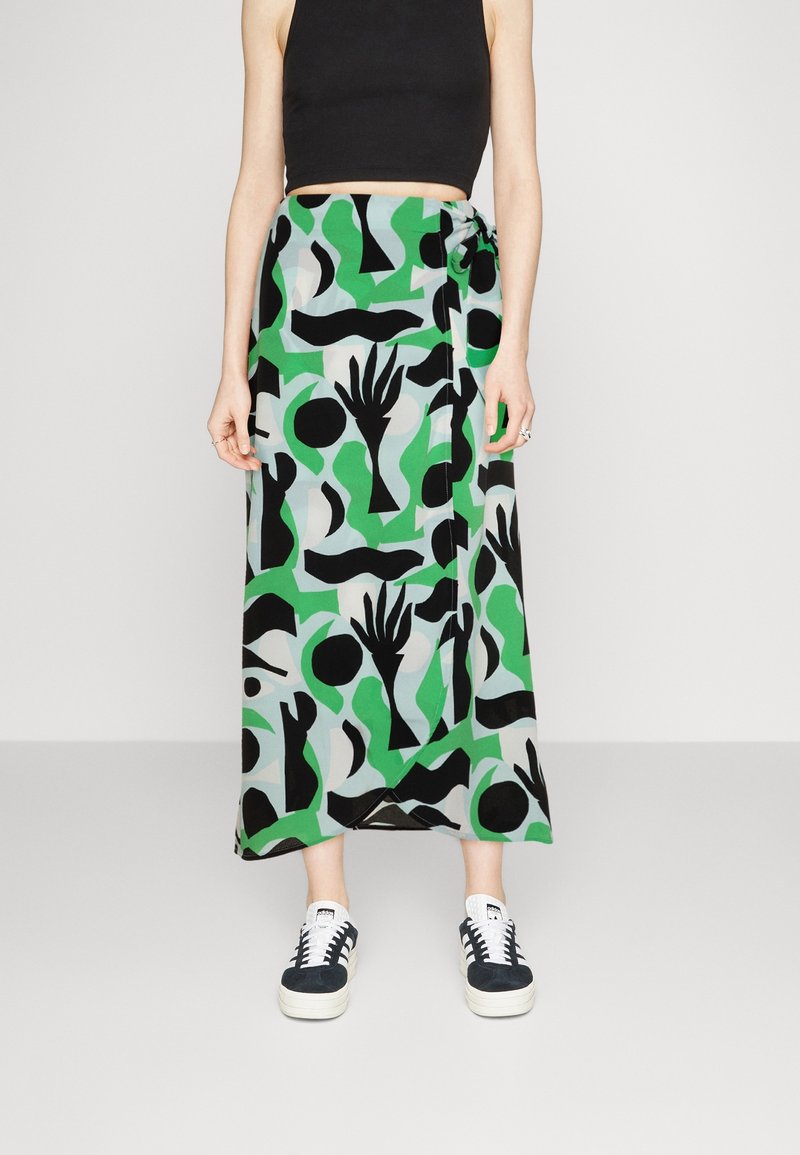 Maxi rok in groen met zwarte abstracte patronen. Gemaakt van lichte stof, met een striksluiting in de taille en een vloeiende silhouet.