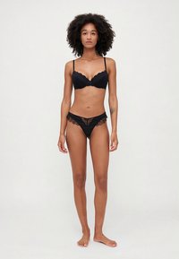 Must pitsist pitsist ja sobivad stringid, millel on võrgusilmade aktsendid, keerukad pitsidetailid, reguleeritavad rihmad ja lihtne disain.