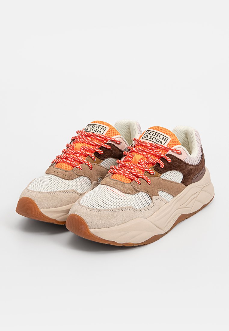 Beżowe i brązowe sportowe sneakersy z materiałów siatkowych i zamszowych, z jaskrawymi pomarańczowymi sznurówkami i pomarańczowym siatkowym językiem. Gumowa podeszwa.