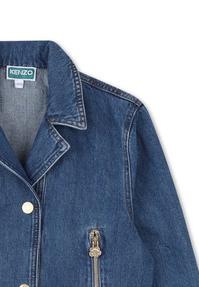 Giacca di jeans di colore blu scuro con colletto a rotondo, accessori in oro e tasca laterale con zip. Presenta cuciture a contrasto e un'etichetta interna.