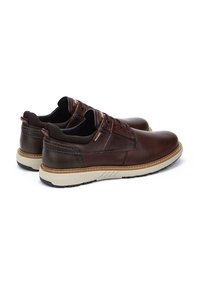 Zapatos de cuero marrón con puntera redondeada, suela de goma plana y acentos en crema contrastantes. Cuentan con cordones y un interior de malla texturizada.