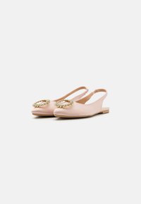 Bailarinas rosas de tipo slingback, confeccionadas en material suave, con un acento decorativo circular adornado con pequeñas piedras y hardware dorado.
