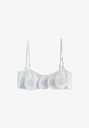 Top bikini corto bianco con dettagli in pizzo smerlato e sottili spalline regolabili su sfondo semplice.