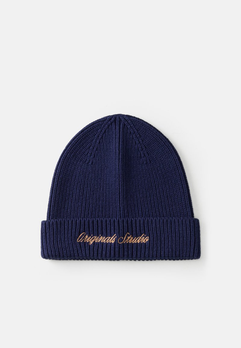 Jūras spēku adīta beanie ar ribotu tekstūru un salocītu maliņu, uz kuras ir izšūts teksts "Originals Studio" zeltā.