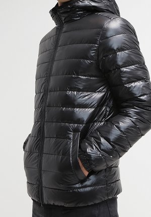 Parka noire avec une finition brillante, motif matelassé horizontal, fermeture éclair à l'avant et capuche. Dispose de poches latérales et de poignets élastiques.