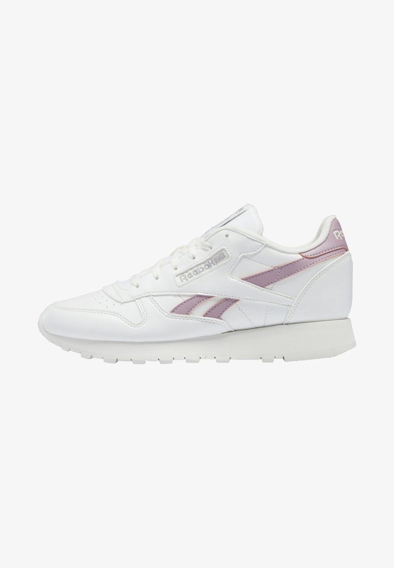 Baskets basses blanches Reebok avec des bandes de logo rose clair et une semelle blanche, vues de l'intérieur.