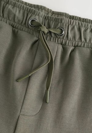 Oliven grønne joggingbukser med elastisk talje og fletdet snor med sølv-øjer, lavet af blødt, struktureret stof.