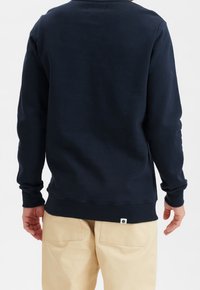 Sudadera azul marino hecha de mezcla de algodón, con cuello redondo, puños y dobladillo acanalados, con una pequeña etiqueta de logo cerca de la parte inferior.