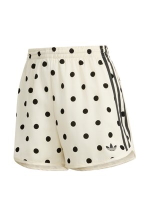 Kremshorts med sorte polkaprikker, sort Adidas-logo og tre sorte striber ned langs siderne, synlig elastisk taljebånd.
