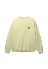 Sweat-shirt jaune clair à col rond avec manches longues et un petit logo sombre en forme de cœur sur la poitrine gauche indiquant "Pacific Republic."