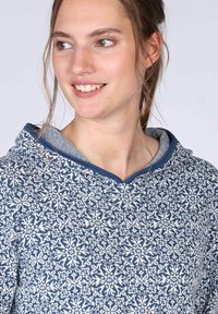 Strickpullover mit Kapuze in Dunkelblau, weißen Schneeflockenmuster, strukturiertem Stoff und kontrastierendem blauen Saum am Hals.