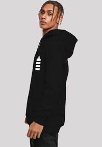 Black hooded sweatshirt with a front pocket, featuring white stripes and a graphic on the left chest. Smooth fabric with ribbed cuffs.