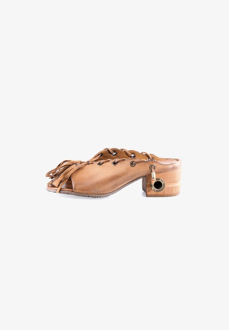 Mule en cuir caramel avec un petit talon bloc, bout ouvert, détails à lacets, franges à pampilles sur le devant et œillets métalliques ronds sur les côtés.