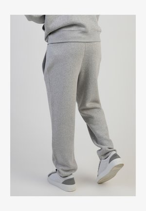 Gray sweatpants with a relaxed fit, featuring an elastic waistband and side pockets. Paired with light gray sneakers.