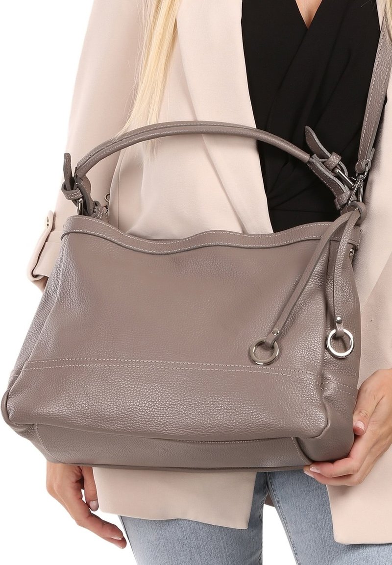 Sac à main en cuir gris avec une finition texturée, double poignées, une bandoulière réglable et des accents en métal ; forme douce et décontractée.