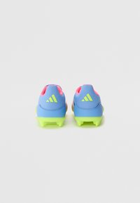 Blue athletic cleats with pink and neon green accents. Textured material, rounded toe design, and prominent brand logo on the back.
