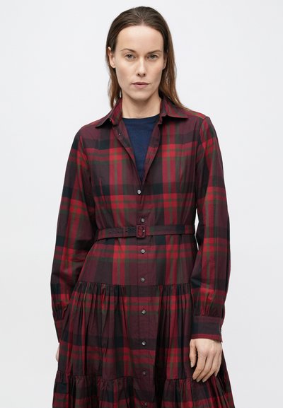 Sarkans un melns pleda raksta kleita ar pogām priekšpusē, apkakli, garām piedurknēm un piegulošu jostasvietu ar atbilstošu jostu. Pl�ūstošs daudzpakāpju svārks.