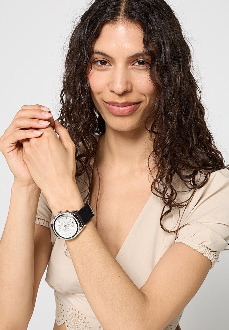 Silberne Armbanduhr mit weißem Zifferblatt, schwarzem Lederarmband und drei zusätzlichen Nebenzifferblättern für die Chronographenfunktion.