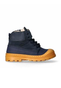 Stivale alla caviglia in pelle blu navy con suola in gomma color tan, punta rotonda, lacci frontali e due occhielli. Finitura testurizzata con dettagli di cucitura.