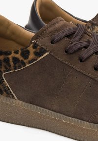 Hnědé semišové tenisky s leopardím vzorem, perforacemi a hnědými tkaničkami. Mají strukturovanou, průhlednou gumovou podrážku.