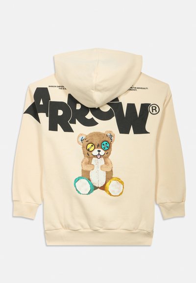 Kremfarget hettegenser med stor svart "ARROW" tekst og et grafisk bilde av en teddybjørn med mismatchede fargerike knappeøyne på baksiden.