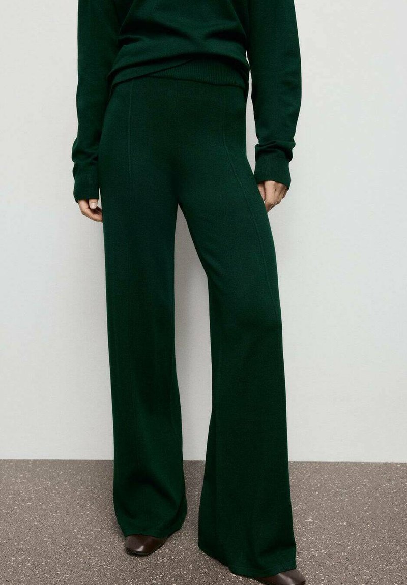 Pantalones de pierna ancha de punto verde con una textura suave y cintura elástica, combinados con una parte superior a juego, sobre un fondo neutro.