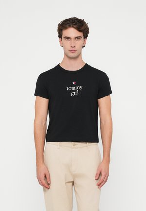 Black cotton t-shirt with short sleeves and crew neck. Features "tommy girl" text and a small star logo in the center.