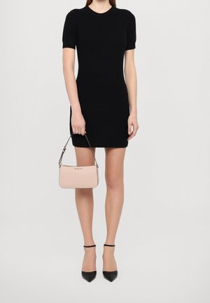Black ribbed knit dress with short sleeves; paired with a small pink handbag featuring a thin strap; model wearing black pointed heels.