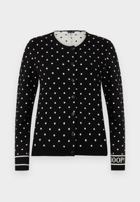 Μαύρο καζάκα με κουμπιά και λευκές πουά, στρογγυλή λαιμόκοψη και κείμενο "JOOP!" στον αριστερό καρπό.