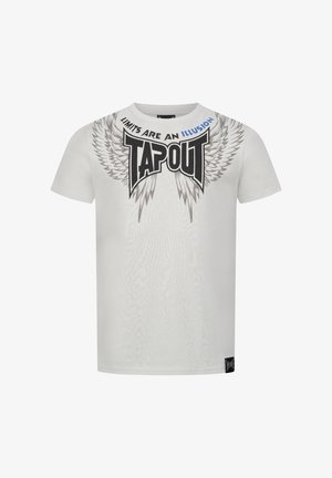 T-shirt en coton blanc avec un logo et un graphisme d'ailes noirs "TAPOUT". Le texte dit "LES LIMITES SONT UNE ILLUSION." Manches courtes, coupe classique.