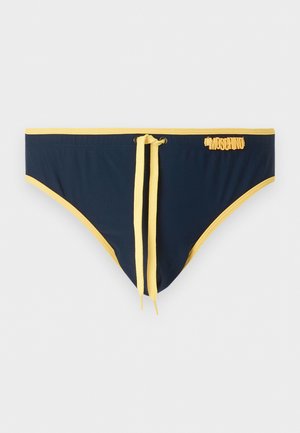 Tumesinised ujumispüksid kollase äärega ja nööriga, esiküljel paremal pool väike kollane Moschino logo.