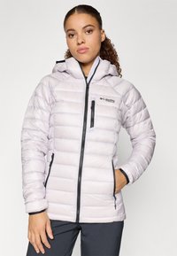 Világoslila puffos dzseki kapucnival, fekete cipzárral és kiegészítőkkel, steppelt kialakítással és kézmelegítő zsebekkel. Hőszigetelt, időjárásálló anyagból készült.