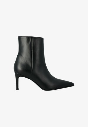 Bottine en cuir noir avec un bout pointu, un talon aiguille et une texture lisse. Présente une couture à l'arrière et un design minimaliste.