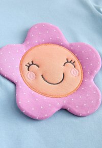 Šviesiai mėlynas audinys su siuvinėtu rožiniu gėlių aplikacija, baltais taškeliais, oranžiniu centru ir siuvinėtomis veido detalėmis.