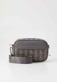 Lacoste rankinė per petį su geometriniu raštu tamsiai pilkos ir rudos spalvos, su lygiu paviršiumi, užtrauktuku ir nuimamu audinio dirželiu.