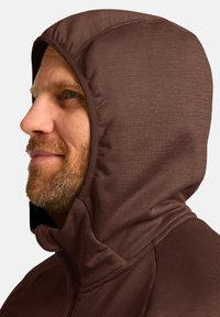 Bruine hoodiejack met een gladde stof, voorzien van een aansluitende capuchon en een ritsluiting, met een zichtbare textuur en naden.